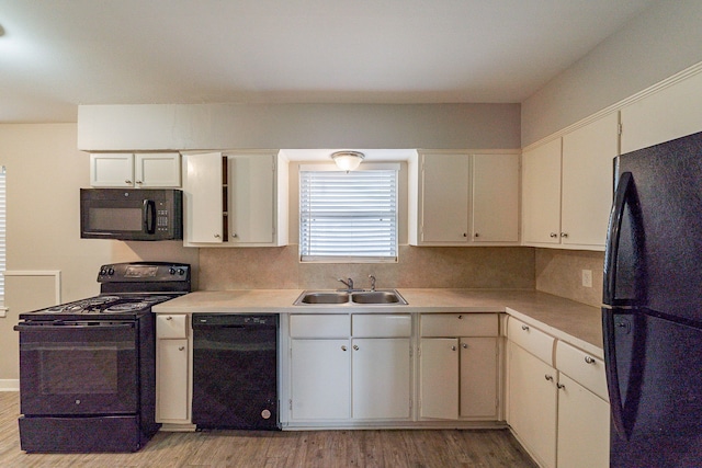 kitchen featuring black appliances, sink, light hardwood / wood-style flooring, tasteful backsplash, and white cabinetry