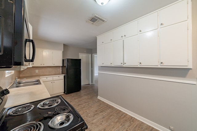 kitchen with white cabinetry, sink, black appliances, and light hardwood / wood-style floors