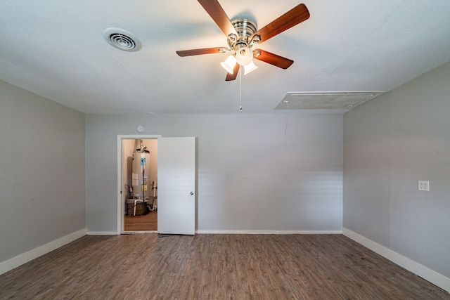 spare room featuring dark hardwood / wood-style floors and gas water heater