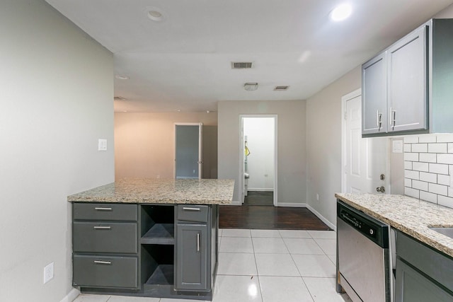 kitchen with gray cabinetry, light stone countertops, stainless steel dishwasher, decorative backsplash, and light tile patterned flooring