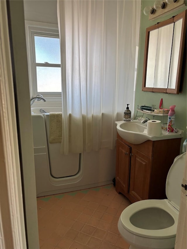 bathroom featuring tile patterned flooring, vanity, toilet, and a tub