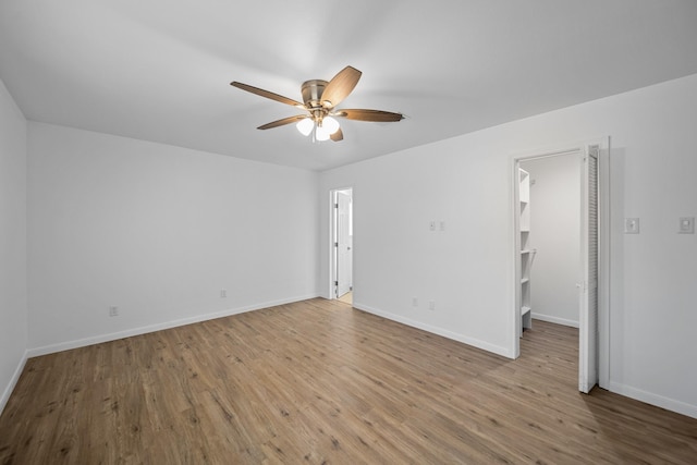 empty room with ceiling fan and light hardwood / wood-style flooring