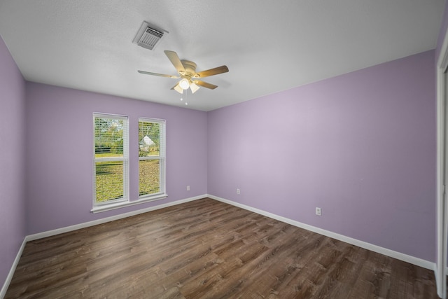 spare room with a textured ceiling, ceiling fan, and dark hardwood / wood-style floors