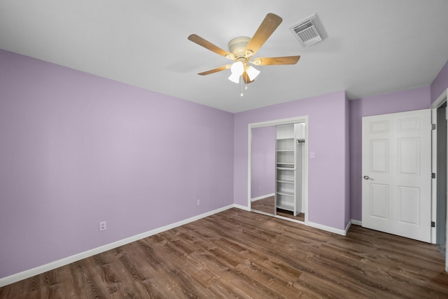 unfurnished bedroom featuring ceiling fan, dark wood-type flooring, and a closet