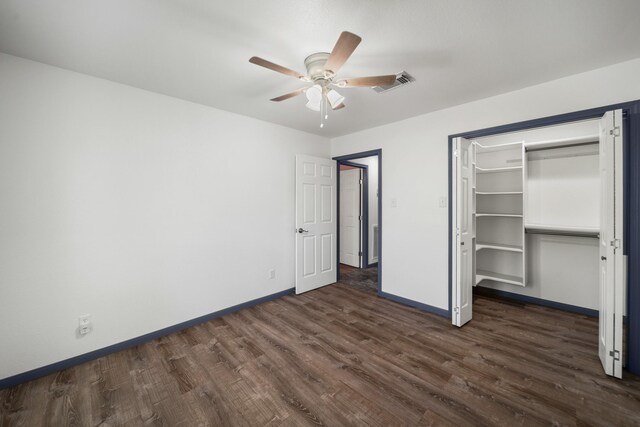 unfurnished bedroom featuring ceiling fan, dark hardwood / wood-style flooring, and a closet