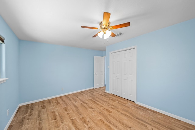 unfurnished bedroom featuring ceiling fan, a closet, and light hardwood / wood-style flooring