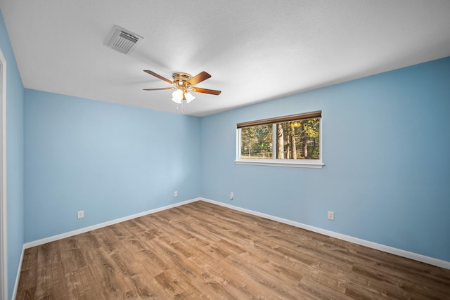 spare room featuring ceiling fan, wood-type flooring, and a textured ceiling