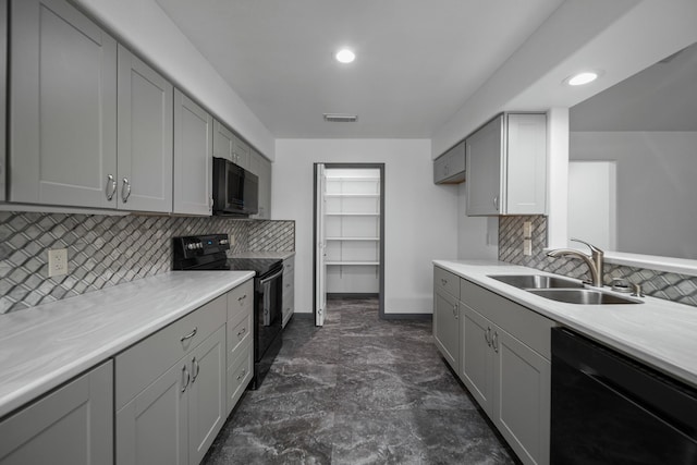 kitchen featuring sink, tasteful backsplash, gray cabinetry, and black appliances