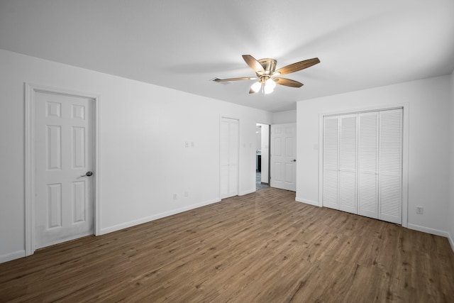 unfurnished bedroom featuring ceiling fan and dark hardwood / wood-style floors