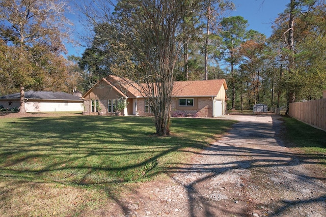 single story home featuring a garage, an outdoor structure, and a front lawn