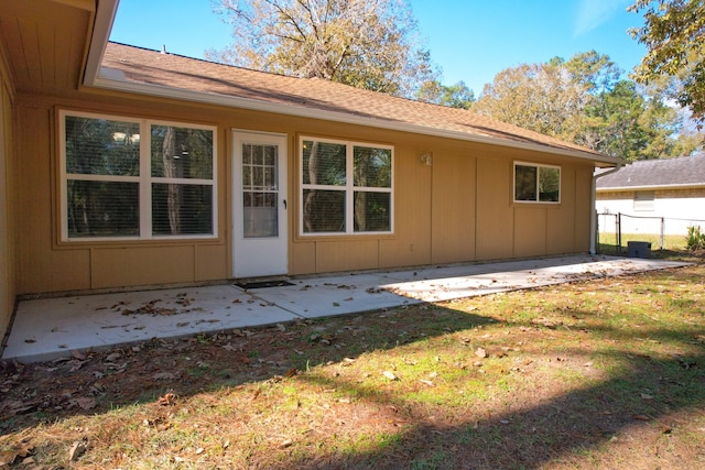 rear view of house with a lawn and a patio