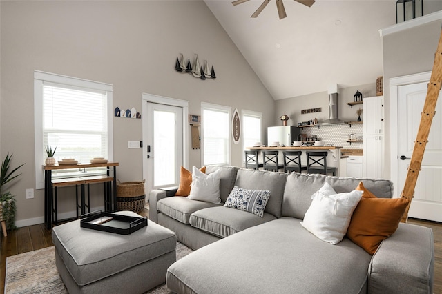 living room featuring dark hardwood / wood-style floors, high vaulted ceiling, and ceiling fan