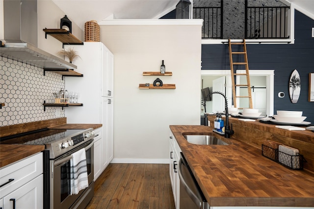 kitchen with sink, wall chimney exhaust hood, dark hardwood / wood-style floors, butcher block counters, and stainless steel appliances