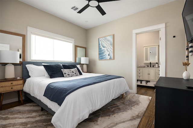 bedroom featuring ceiling fan, sink, dark wood-type flooring, and connected bathroom