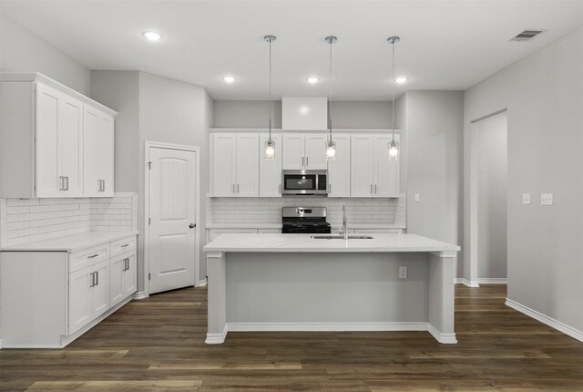 kitchen with dark wood-type flooring, white cabinets, sink, decorative light fixtures, and stainless steel appliances