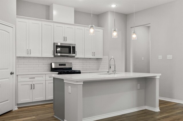 kitchen with white cabinetry, sink, a kitchen island with sink, and appliances with stainless steel finishes