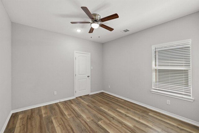 empty room with hardwood / wood-style floors and ceiling fan