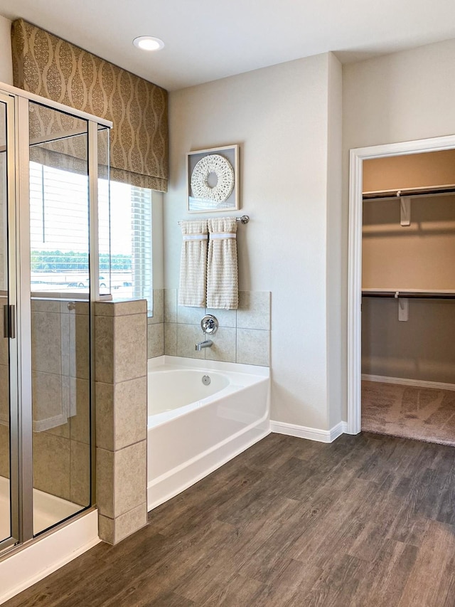 bathroom featuring hardwood / wood-style floors and plus walk in shower