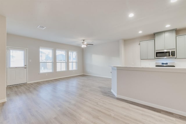 kitchen with gray cabinets, ceiling fan, and light hardwood / wood-style floors