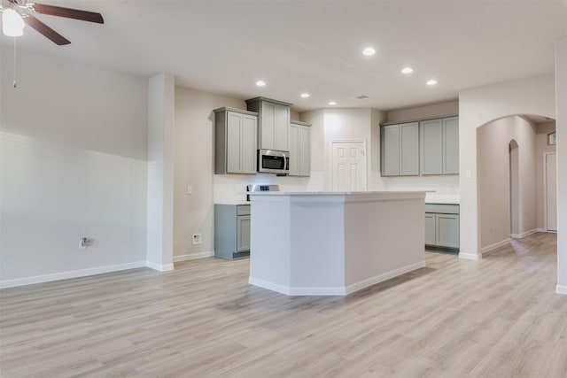 kitchen with gray cabinets, ceiling fan, and light hardwood / wood-style flooring