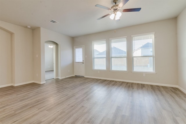 empty room with light hardwood / wood-style floors, ceiling fan, and a healthy amount of sunlight