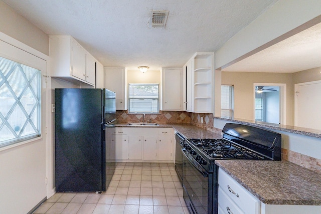 kitchen with sink, white cabinets, black appliances, and a textured ceiling