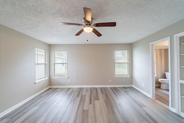 unfurnished room with ceiling fan, light hardwood / wood-style floors, and a textured ceiling