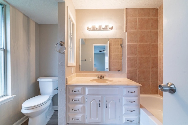 bathroom featuring vanity, ceiling fan, toilet, and a textured ceiling