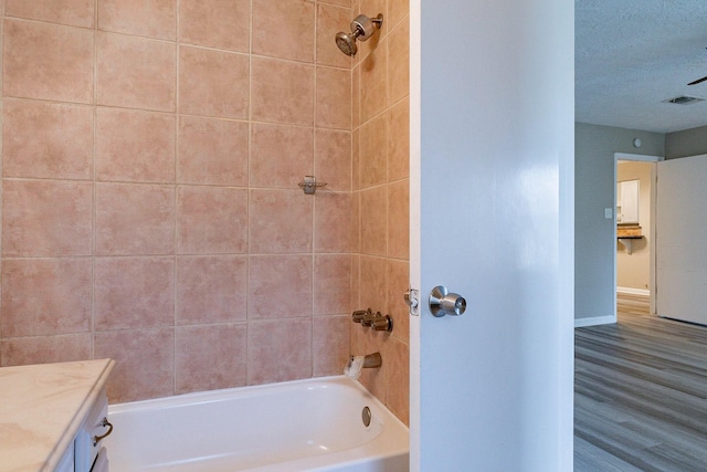 bathroom featuring vanity, tiled shower / bath combo, and hardwood / wood-style flooring