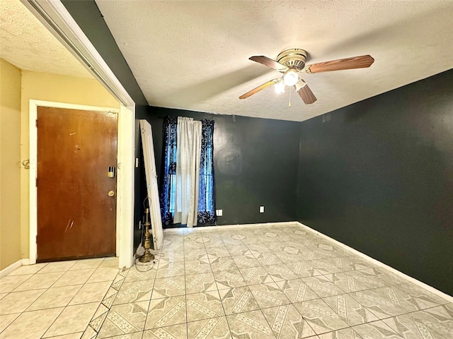 tiled spare room with a textured ceiling and ceiling fan