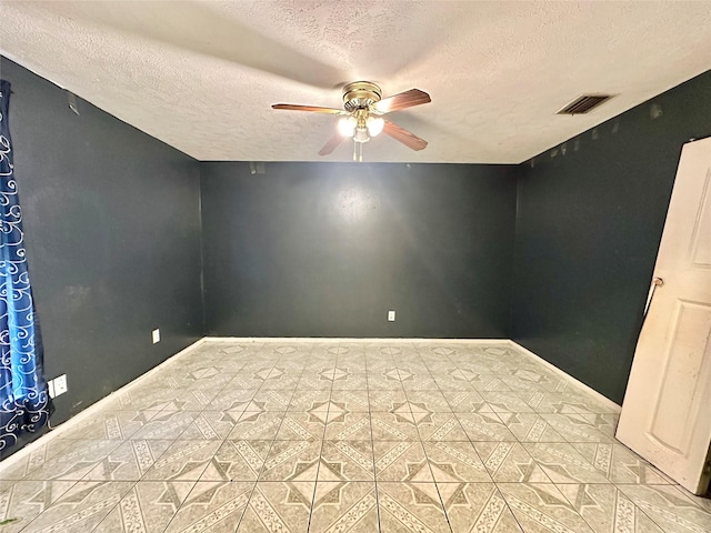 unfurnished room with ceiling fan and a textured ceiling