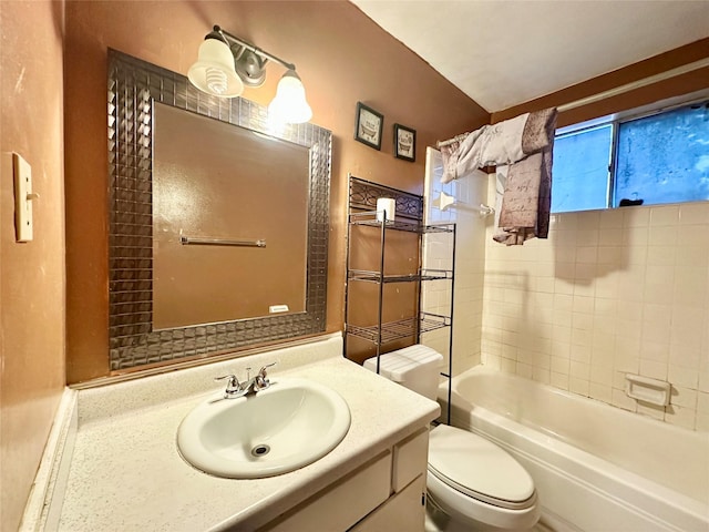 full bathroom with vanity, tiled shower / bath combo, and toilet