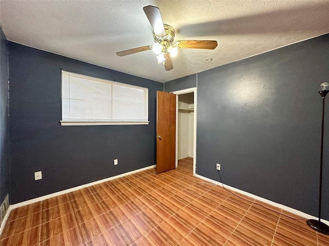 unfurnished bedroom with ceiling fan, a textured ceiling, and a closet