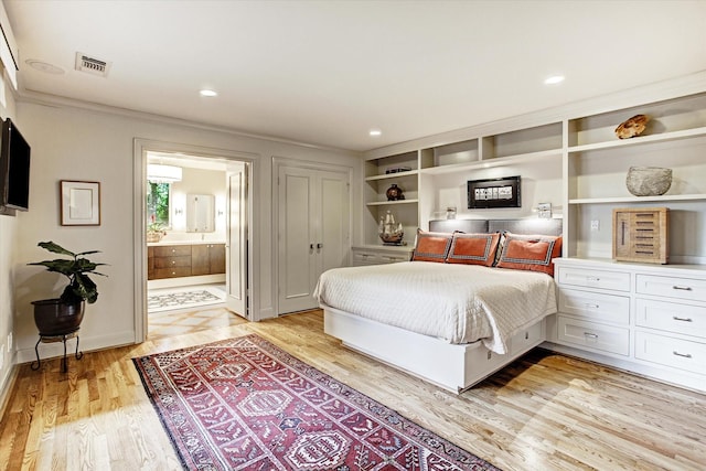 bedroom featuring light wood-type flooring, connected bathroom, and crown molding