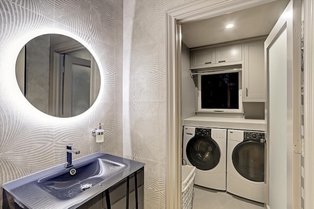 laundry room featuring light tile patterned floors, washer and clothes dryer, and sink