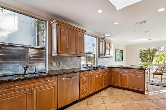 kitchen with stainless steel appliances, tasteful backsplash, crown molding, dark stone counters, and light tile patterned flooring