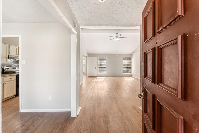 entryway with ceiling fan, light wood-type flooring, and a textured ceiling