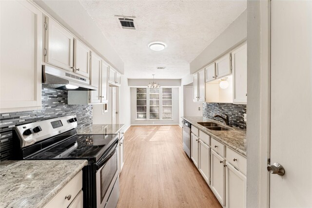 kitchen featuring white cabinetry, hanging light fixtures, and appliances with stainless steel finishes