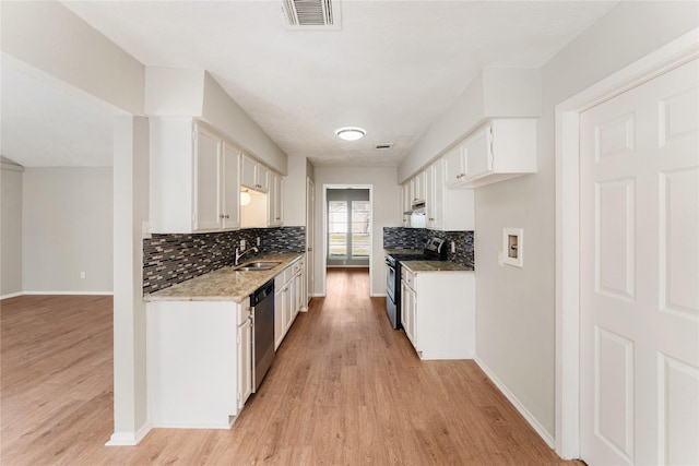 kitchen with stainless steel appliances, white cabinetry, and light hardwood / wood-style floors