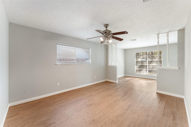 spare room with ceiling fan, a textured ceiling, and light wood-type flooring