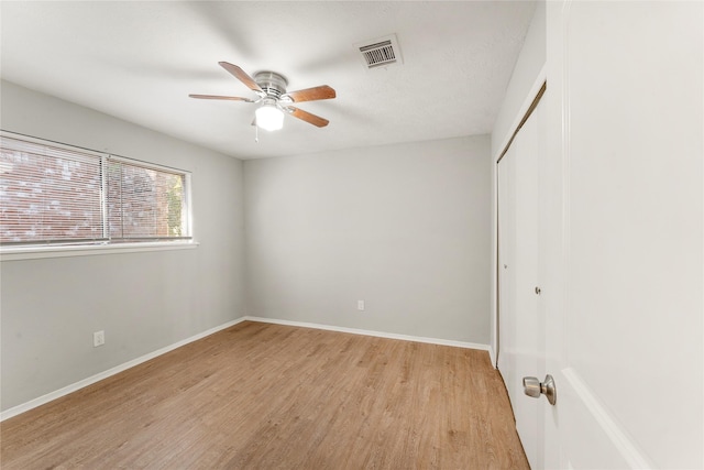 unfurnished bedroom featuring light wood-type flooring, a closet, and ceiling fan