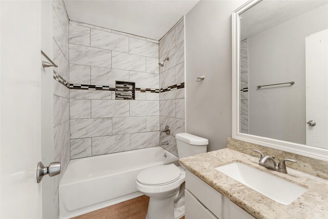 full bathroom featuring vanity, toilet, wood-type flooring, and tiled shower / bath