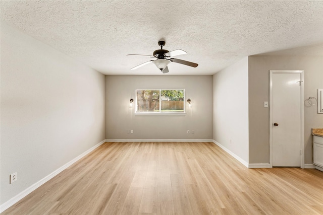 spare room featuring ceiling fan, light hardwood / wood-style floors, and a textured ceiling