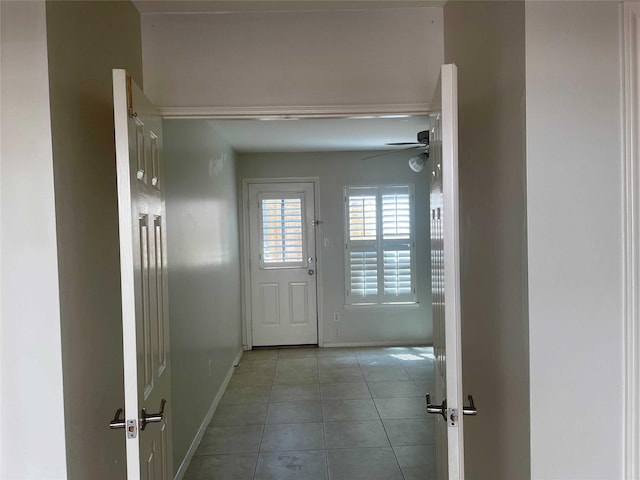 doorway with ceiling fan and light tile patterned floors