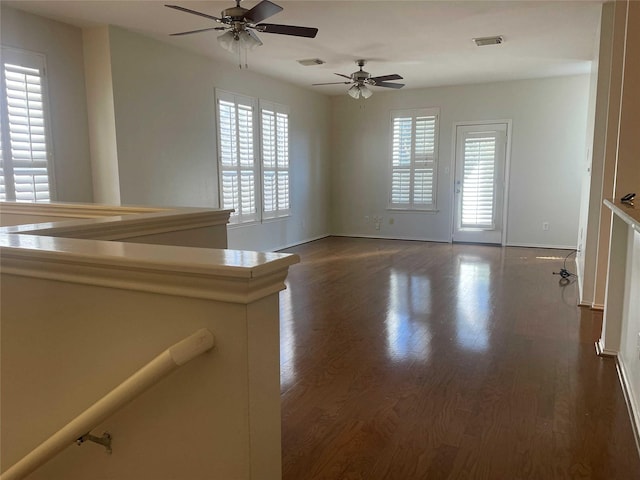 unfurnished room featuring ceiling fan and dark wood-type flooring