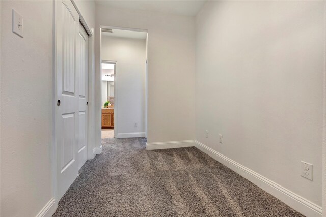 interior space with baseboards, visible vents, and dark carpet