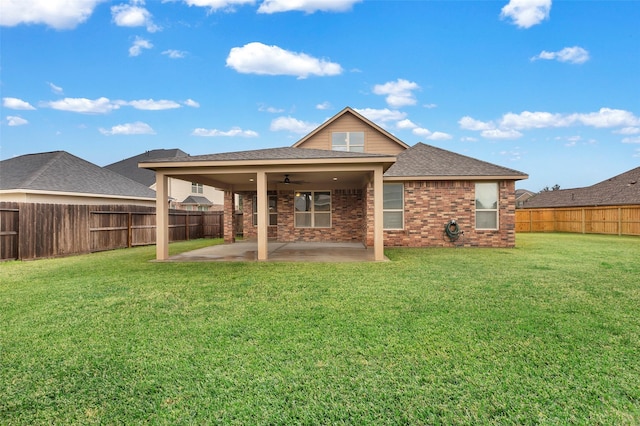 back of house featuring a ceiling fan, a patio, a fenced backyard, a yard, and brick siding