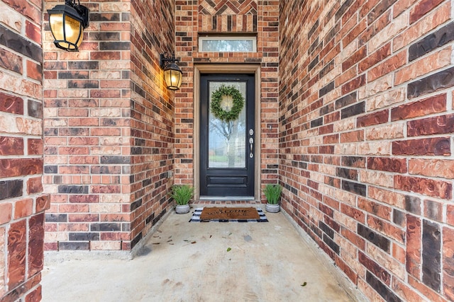 view of exterior entry featuring brick siding