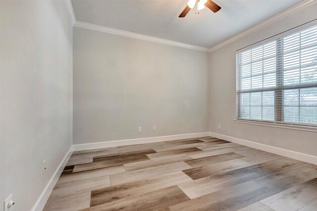 spare room with ornamental molding, light wood-type flooring, a ceiling fan, and baseboards