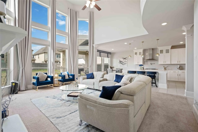 living room featuring light carpet, a high ceiling, and a wealth of natural light